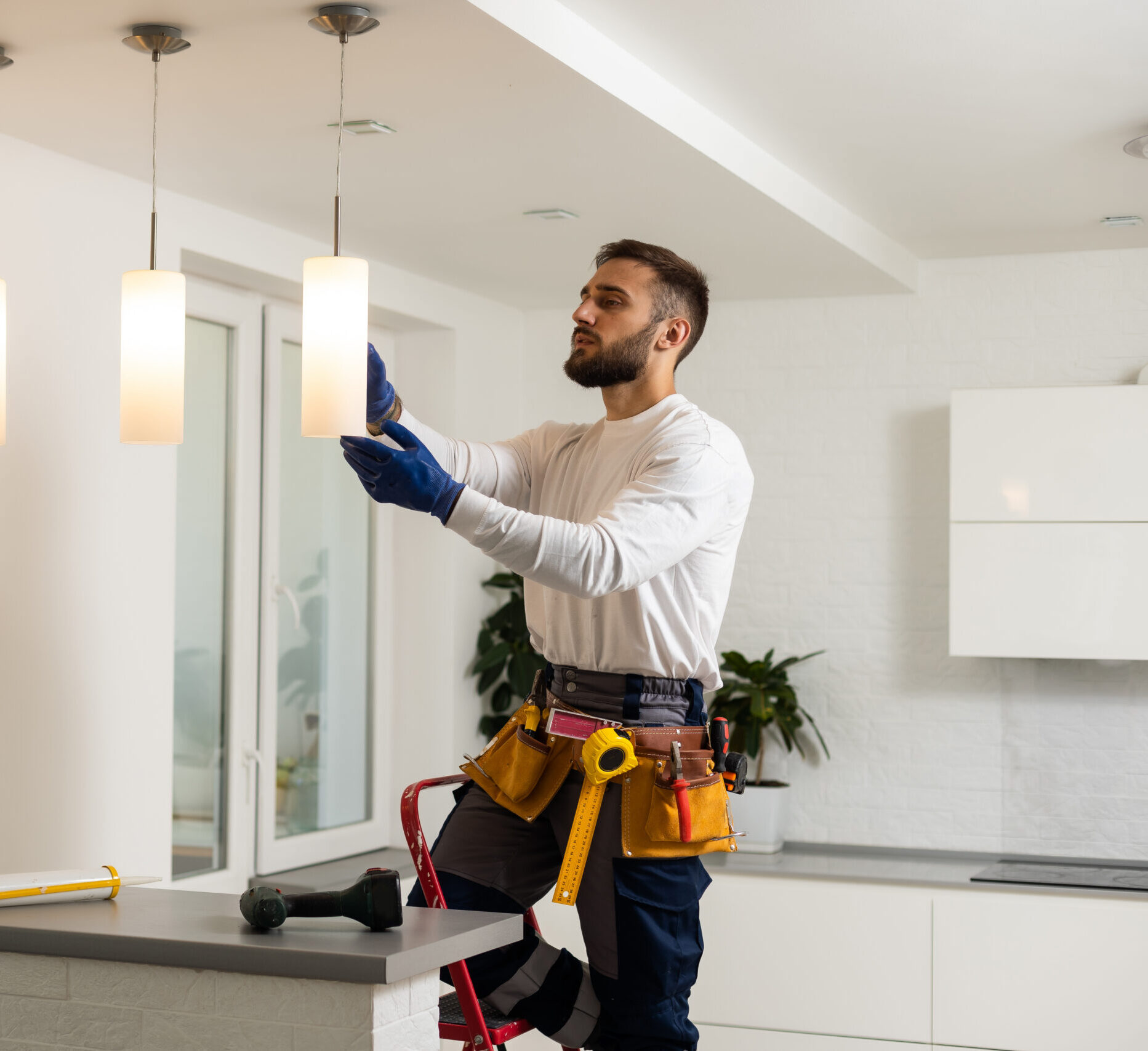 Electrician installs lamp lighting and spot loft style on ceiling.